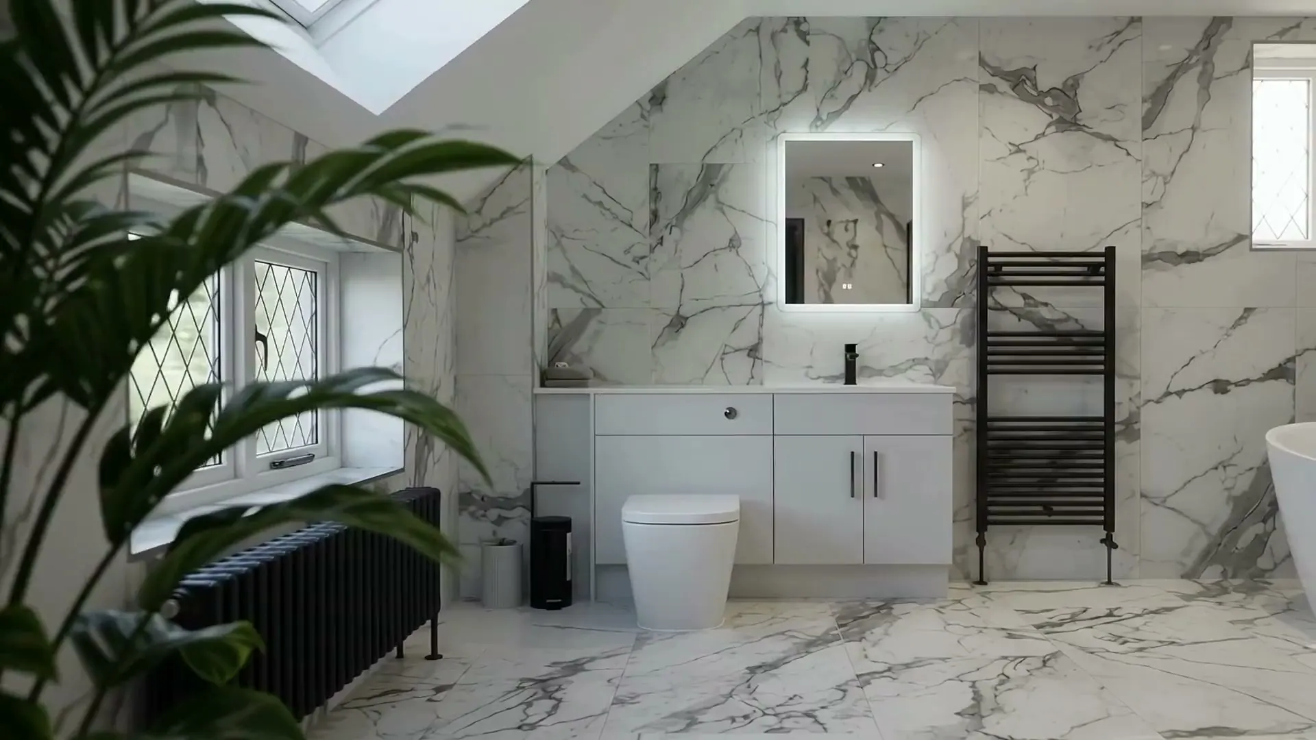 Bathroom with marble-effect tiles, an illuminated mirror above a fitted vanity unit and a black towel radiator